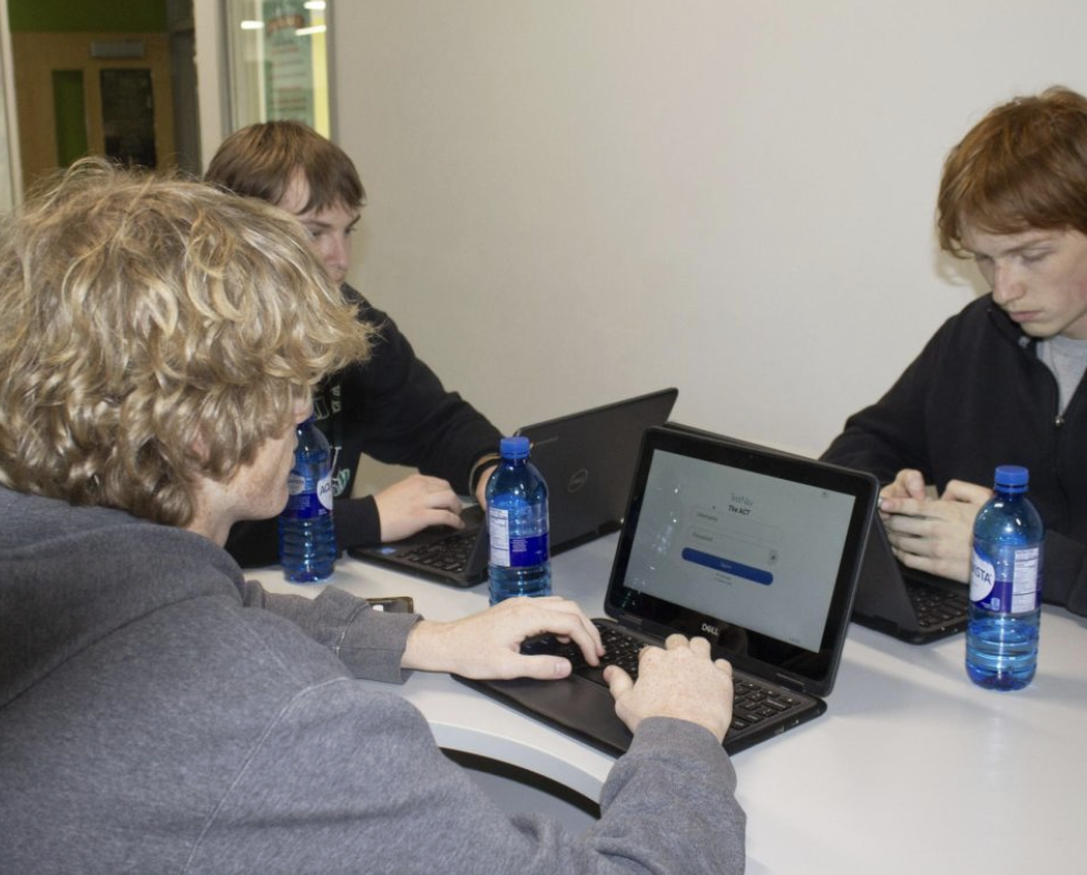 Eamonn Mahoney, Dominic Swanson and Ryan Box work on assignments in the hallway during their class.

